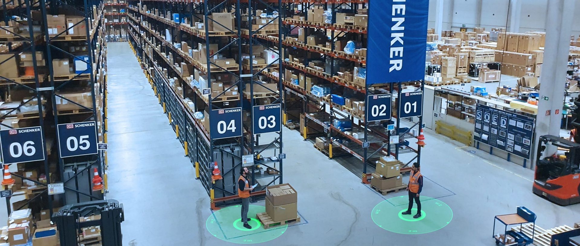 Birdseye view of employees using social distancing wearables in a warehouse